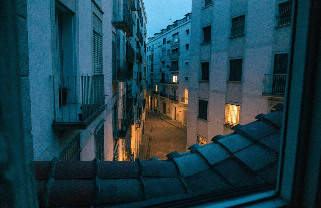 Vista de una calle residencial de Madrid al atardecer desde la ventana de la oficina editorial
